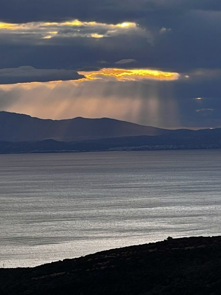 Sun rays through clouds over the sea