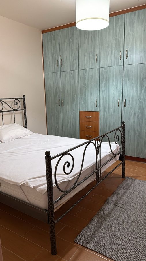 Bedroom with iron bed frame and wardrobe