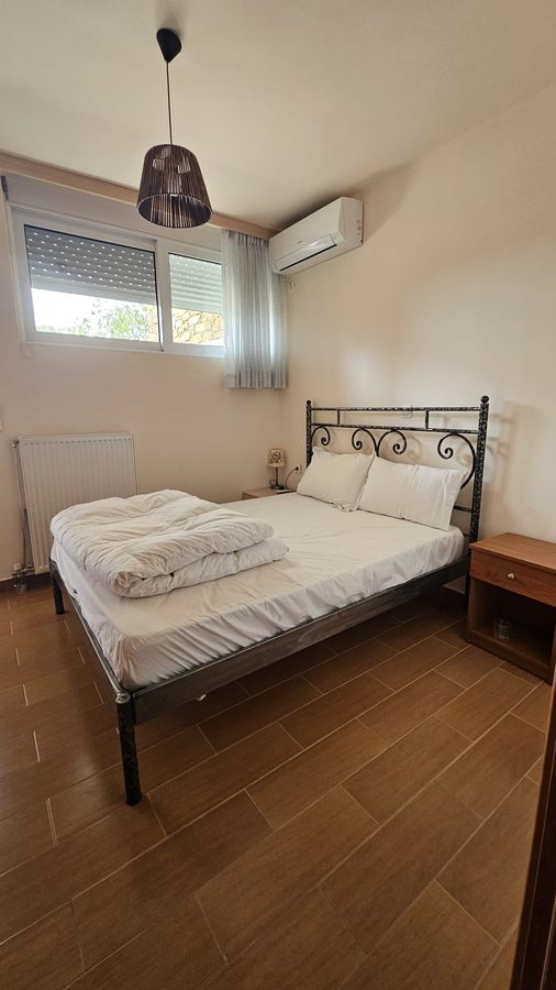 Main bedroom with wrought iron bed and air conditioning