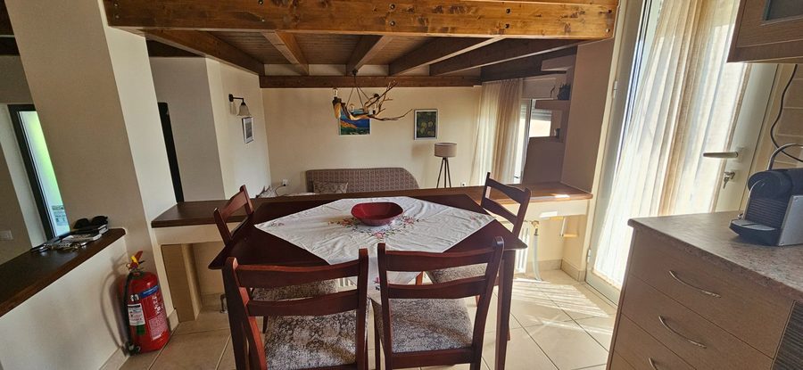 Dining area with wooden beams and artwork